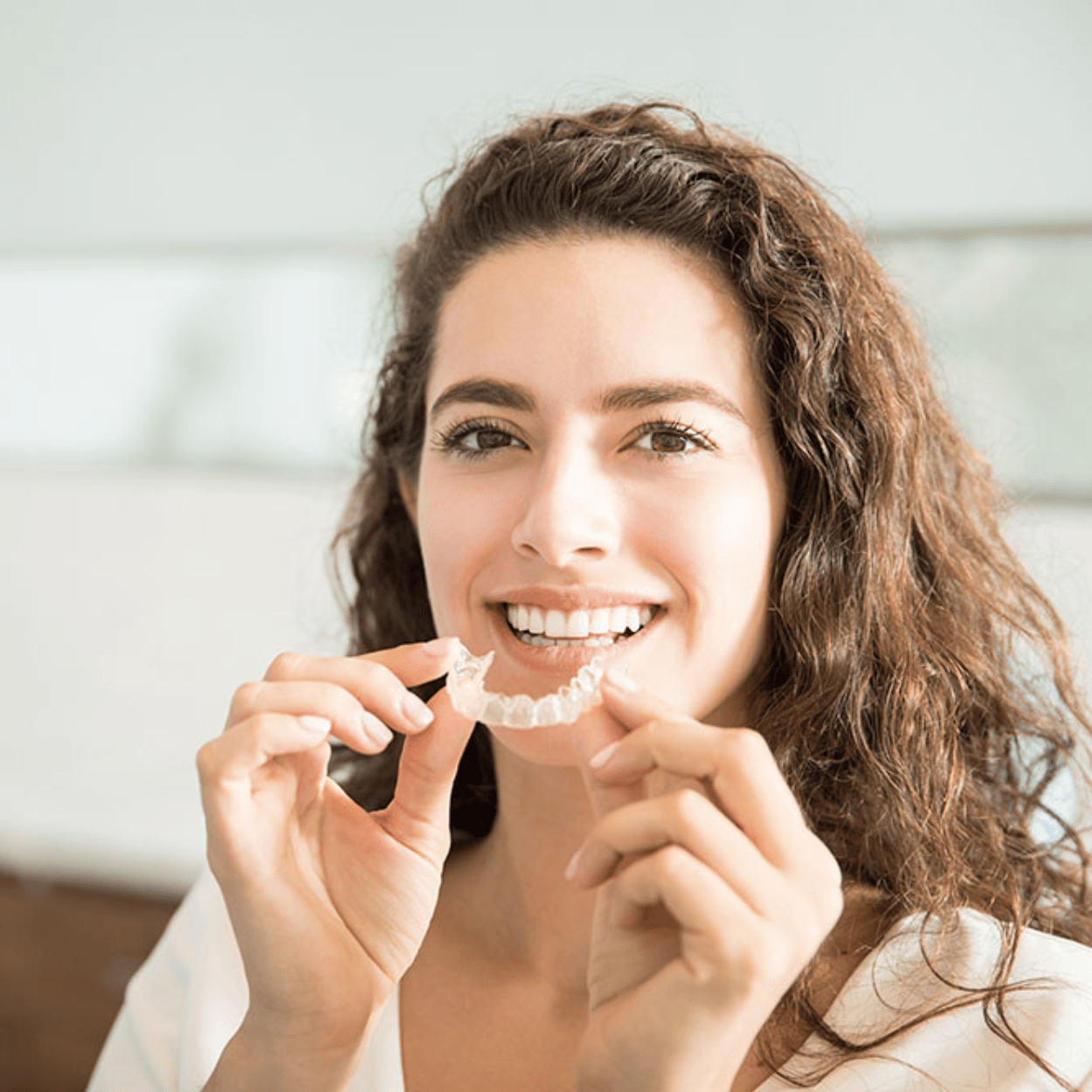 Woman holding a removable clear aligner